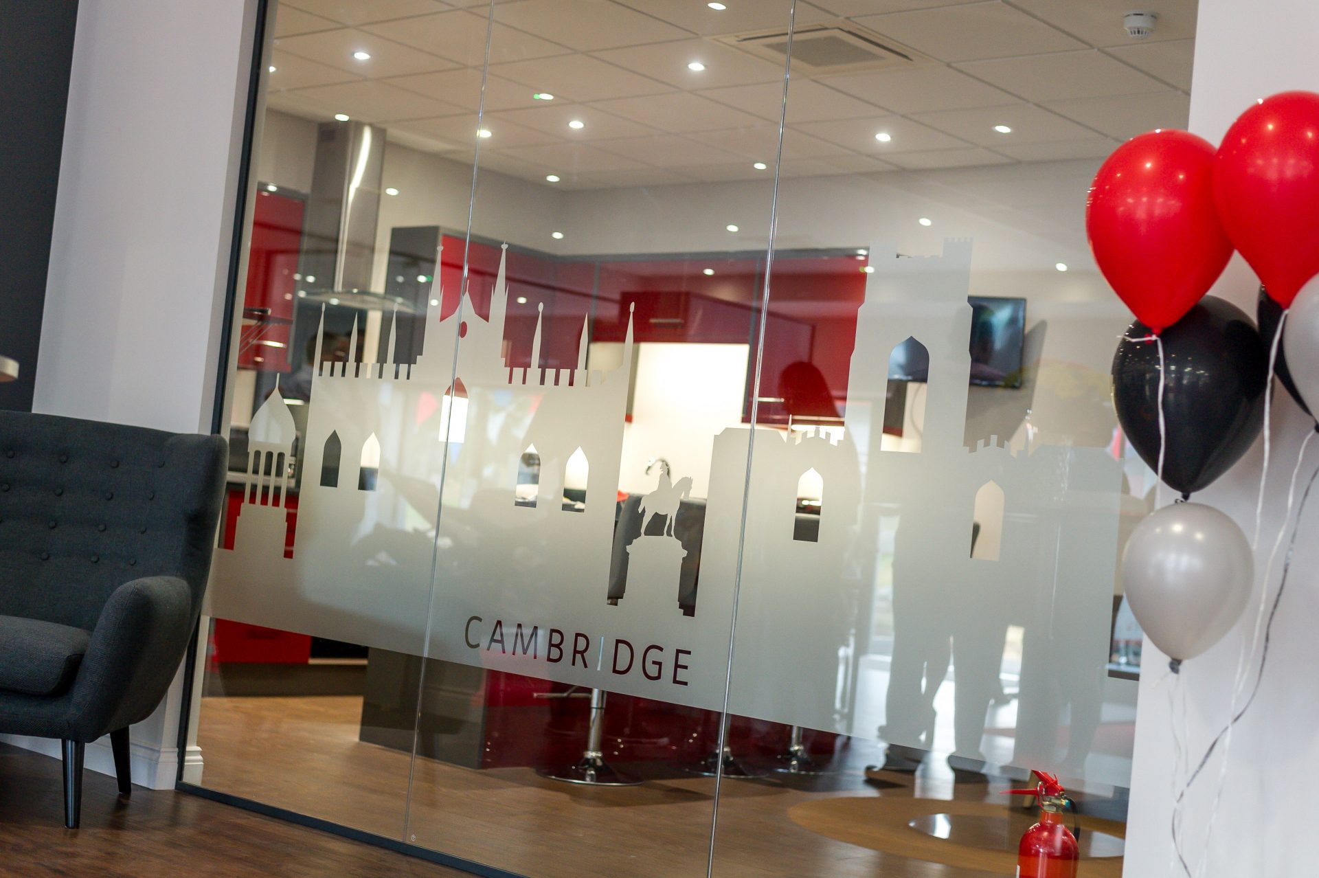 Glass wall section within a solid wall with dark grey metal framework and a solid film design.